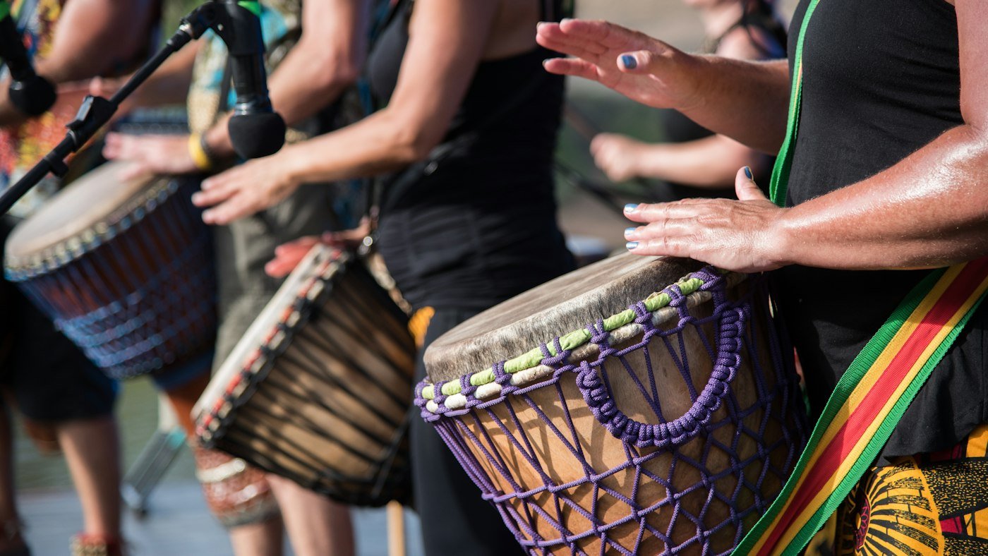 Drummers playing djembe drums at a festival