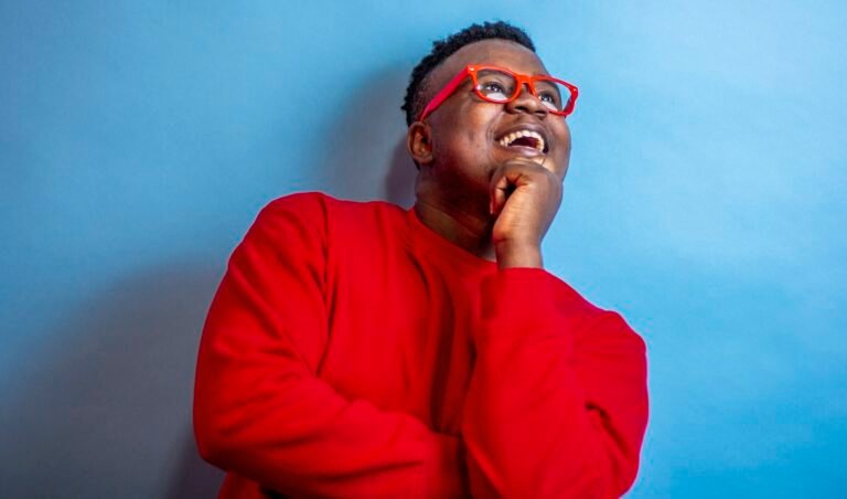 Man in a red sweater smiling thoughtfully