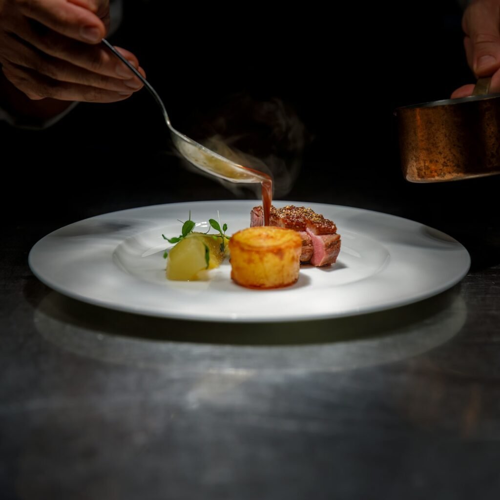 Chef saucing a fine-dining plate