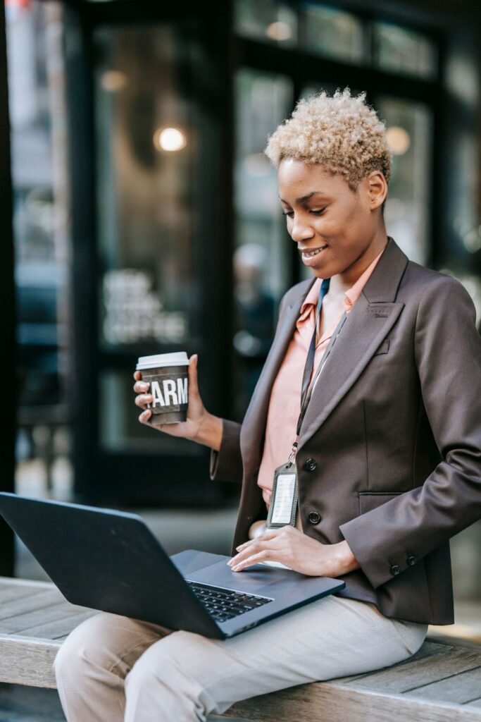 Smiling professional woman with a coffee and laptop